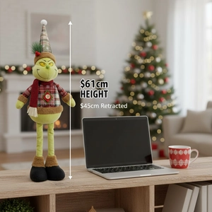 The Grinch Christmas plush toy showing adjustable height of 61cm and 45cm in cozy room