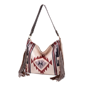 Close-up of Bohemian woven shoulder bag featuring ethnic geometric patterns and long tassels