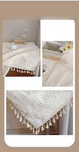 Détail de la broderie marguerite sur tissu en coton et lin avec des franges