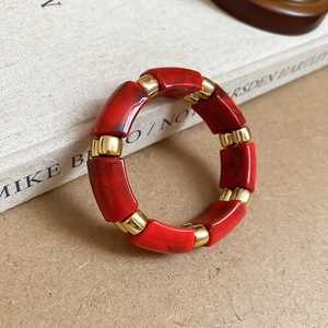 Detail of red marble texture acrylic beads and gold rectangular spacers on the bracelet