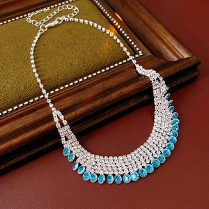Detail of silver tassel necklace with blue oval gems and sparkling rhinestones on velvet