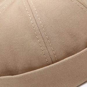 Close-up of khaki docker hat showing twill cotton texture and double stitching