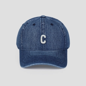 Close-up of a blue denim baseball cap featuring detailed white C letter embroidery