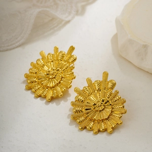 Elegant 18K gold sunburst flower stud earrings with vintage texture on white stone background