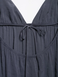 Detail of V-neck drawstring closure and pleated texture on a dark grey summer dress