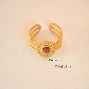 Macro shot of gold-plated bohemian ring with red gemstone and 13mm woven texture detail