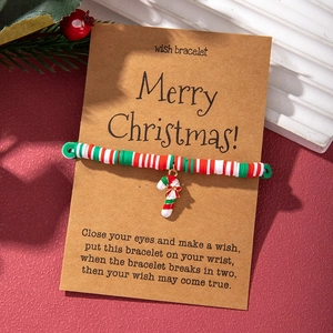 Detailed view of Christmas candy cane bracelet with polymer clay beads and a wish card