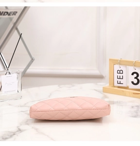 Detail of pink quilted PU leather bag with diamond stitching on marble tabletop