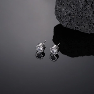 Macro view of silver steel stud earrings featuring white zircon and star motifs