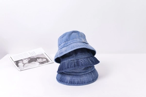Détail de trois bobs en denim délavé aux tons bleus variés avec surpiqûres précises
