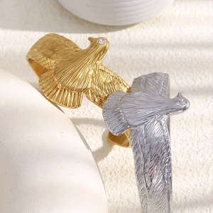 Détails des bracelets aigle en or et argent avec yeux en cristal et plumes sculptées