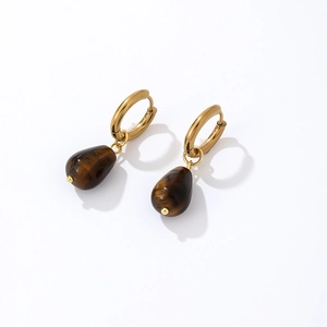 Detail of vintage gold hoop earrings featuring brown tiger eye stone teardrop pendants