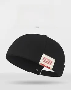 Detail view of a black cotton docker hat featuring a decorative side fabric label