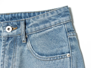 Dettaglio ravvicinato della vita dei jeans con bottone metallico e cuciture delle tasche