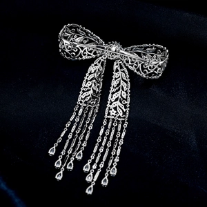 Detailansicht der eleganten Schleifenbrosche mit Zirkonia-Quasten und Süßwasserperlen