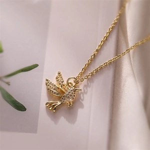 Close-up of a gold bird pendant necklace with sparkling zircon stone setting