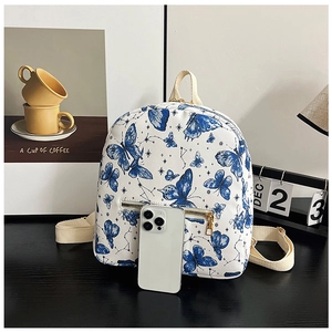 Mini white butterfly backpack shown next to a smartphone to demonstrate its compact size