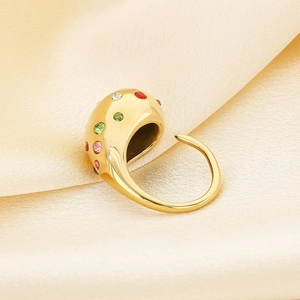 Detail of gold teardrop ring with colorful cubic zirconia on champagne silk backdrop