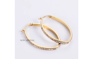 Macro shot of 18K gold plated oval hoop earrings featuring sparkling inlaid crystals