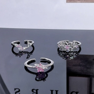 Macro detail of star and moon rings set with pink zircon on a reflective surface