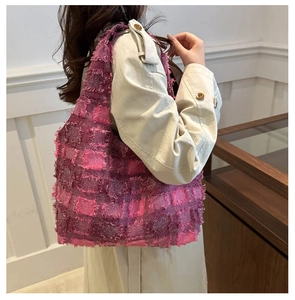 Detail of pink plaid woven tote bag featuring fringe texture and spacious shoulder design