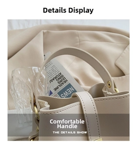 Close-up of beige textured leather handbag featuring golden hardware and stitched handle