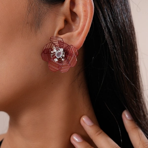 Close-up of retro hollow mesh flower earring with red petals and inlaid crystals