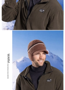 Close-up of brown winter knit baseball cap with earflaps and fleece jacket in snow scene
