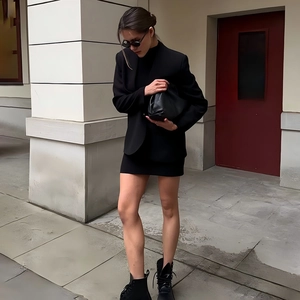 Street style view of a black oversized blazer jacket paired with a matching clutch bag
