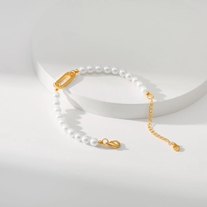Detail shot of French vintage pearl bracelet with 18K gold plated clasp on white stand