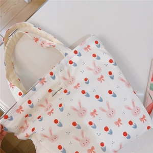 Detail of canvas tote bag featuring cute pink rabbit and tulip floral pattern print