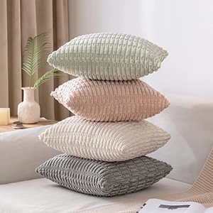 Set of 4 corduroy square pillow covers in green, pink, beige and grey on a sofa