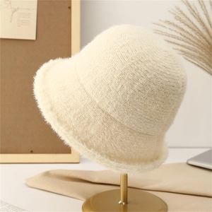 Detailed close-up of soft plush knit bucket hat in beige showing warm fuzzy texture