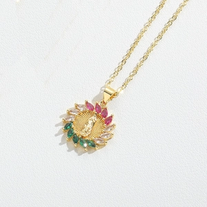 Macro view of gold religious pendant featuring colorful zircon stones and Mary relief