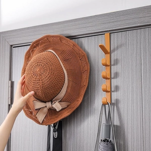 Orangefarbene Türgarderobe mit 5 Haken für Taschen und Hüte an einer grauen Holztür