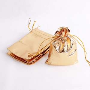 Close-up of golden metallic drawstring pouches showcasing the texture and cinch closure detail