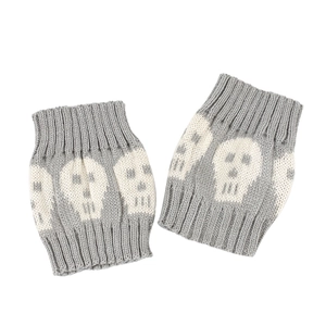 Close-up of grey knitted boot cuffs featuring a white skull pattern and ribbed ends