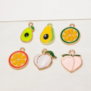 Flat lay of colorful enamel fruit charms including avocado, citrus, and peach for DIY jewelry