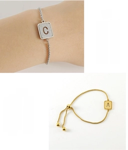 Detail of adjustable stainless steel alphabet bracelets with C and A charms in gold and silver