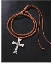 Detail of cross pendant with heart center on brown braided leather bolo tie necklace