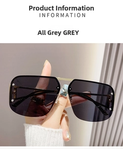Detail of pilot metal sunglasses with grey lenses and gold accents in hand