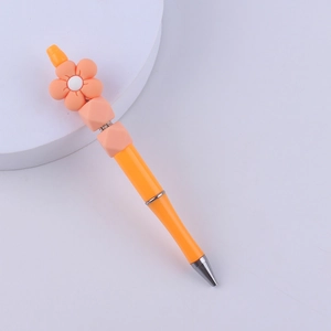 Close-up of orange DIY beaded pen with flower silicone bead and rhinestone detail