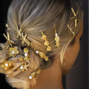Golden starfish hair clips with pearls and rhinestones on hair of a female model