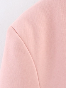 Dettaglio della cucitura della manica e trama del tessuto di un blazer rosa casual