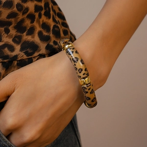 Detail of leopard print tubular stretch bracelet with gold metal rings on wrist