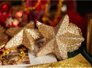 Close-up of golden glitter star ornament with silver hanging loop for Christmas tree