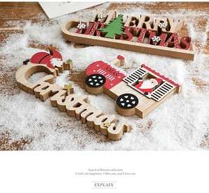 Detailed view of wood Christmas ornaments including a red truck and festive signs on snow