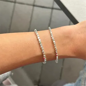 Close-up of minimalist S925 sterling silver beaded bracelet with square cube charms