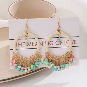 Macro shot of Bohemian round tassel earrings with colorful beads and gold metal frame