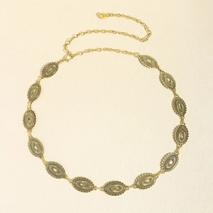 Detail of vintage ethnic gold metal waist chain with intricate engraved oval medallions